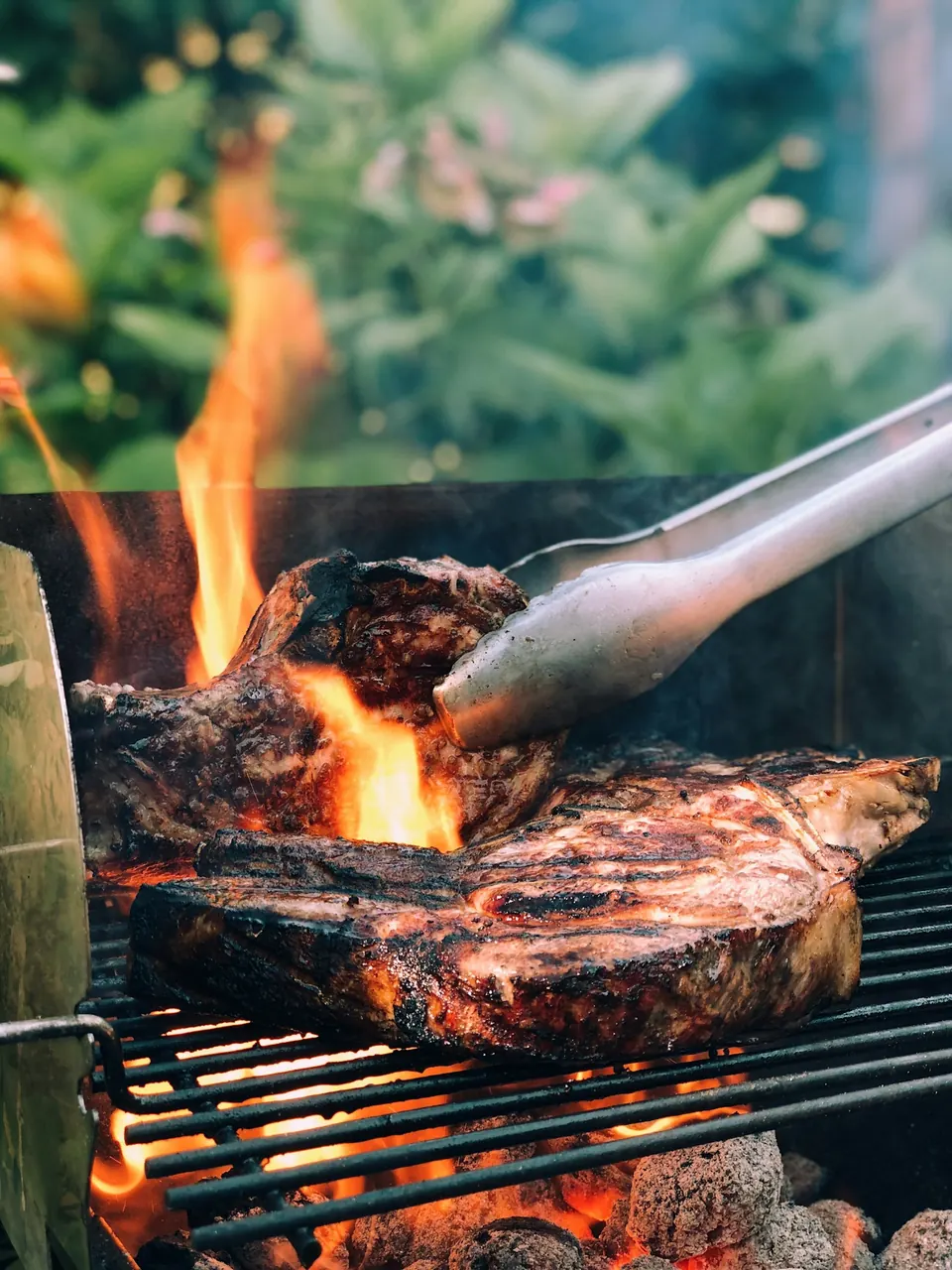 Steak searing over open flames on a grill