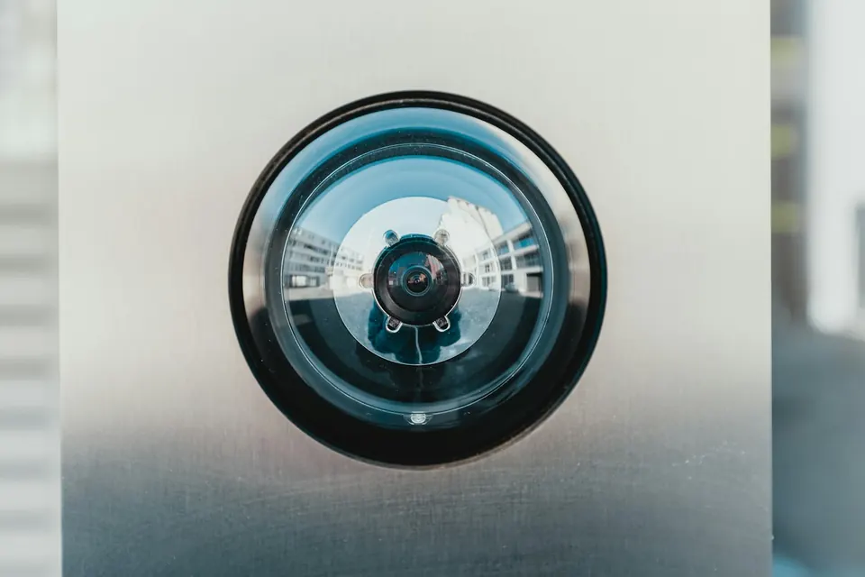Discreet surveillance camera lens mounted in a wall
